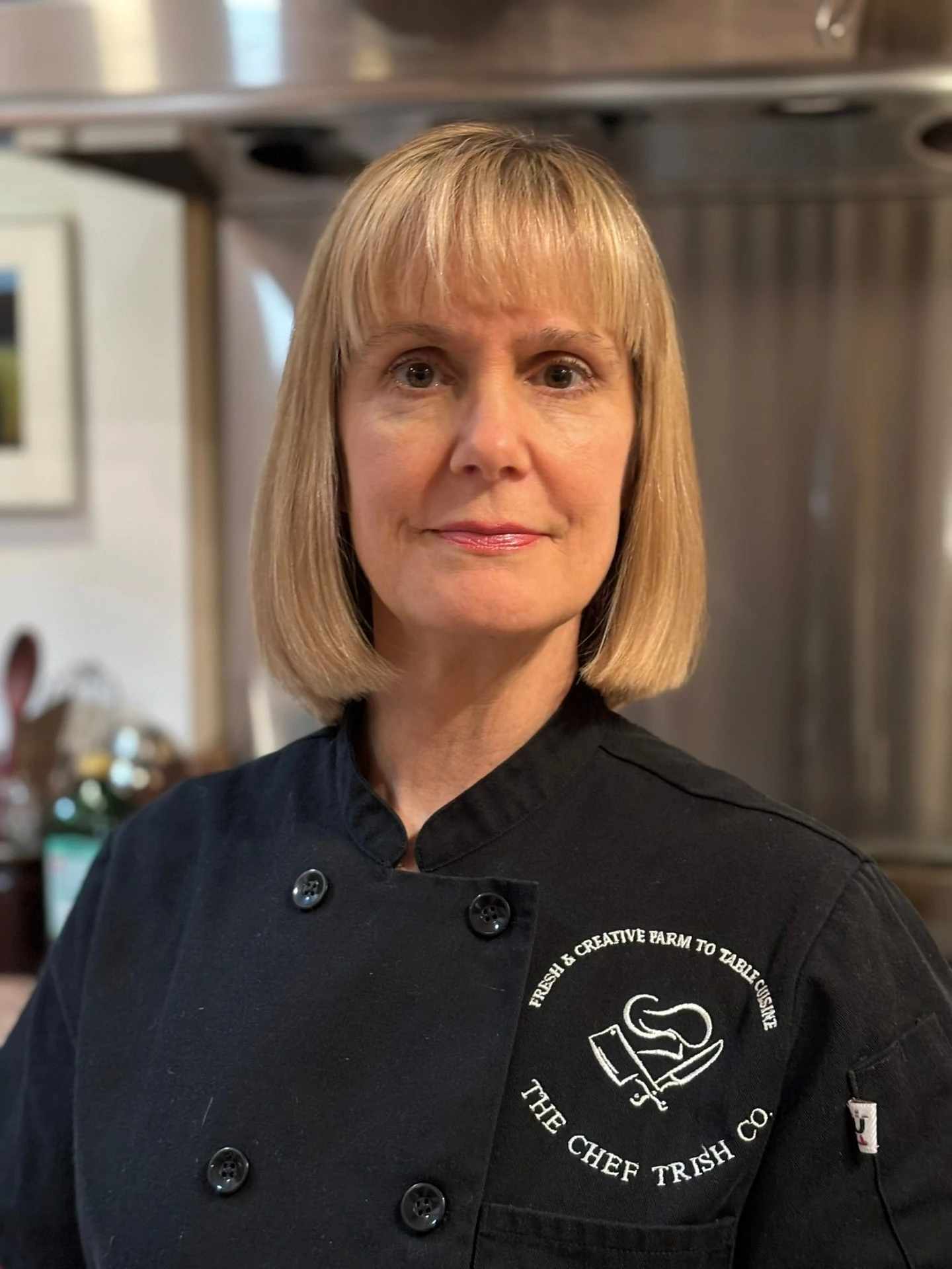 Chef Lissa wearing her black chef coat in a kitchen.