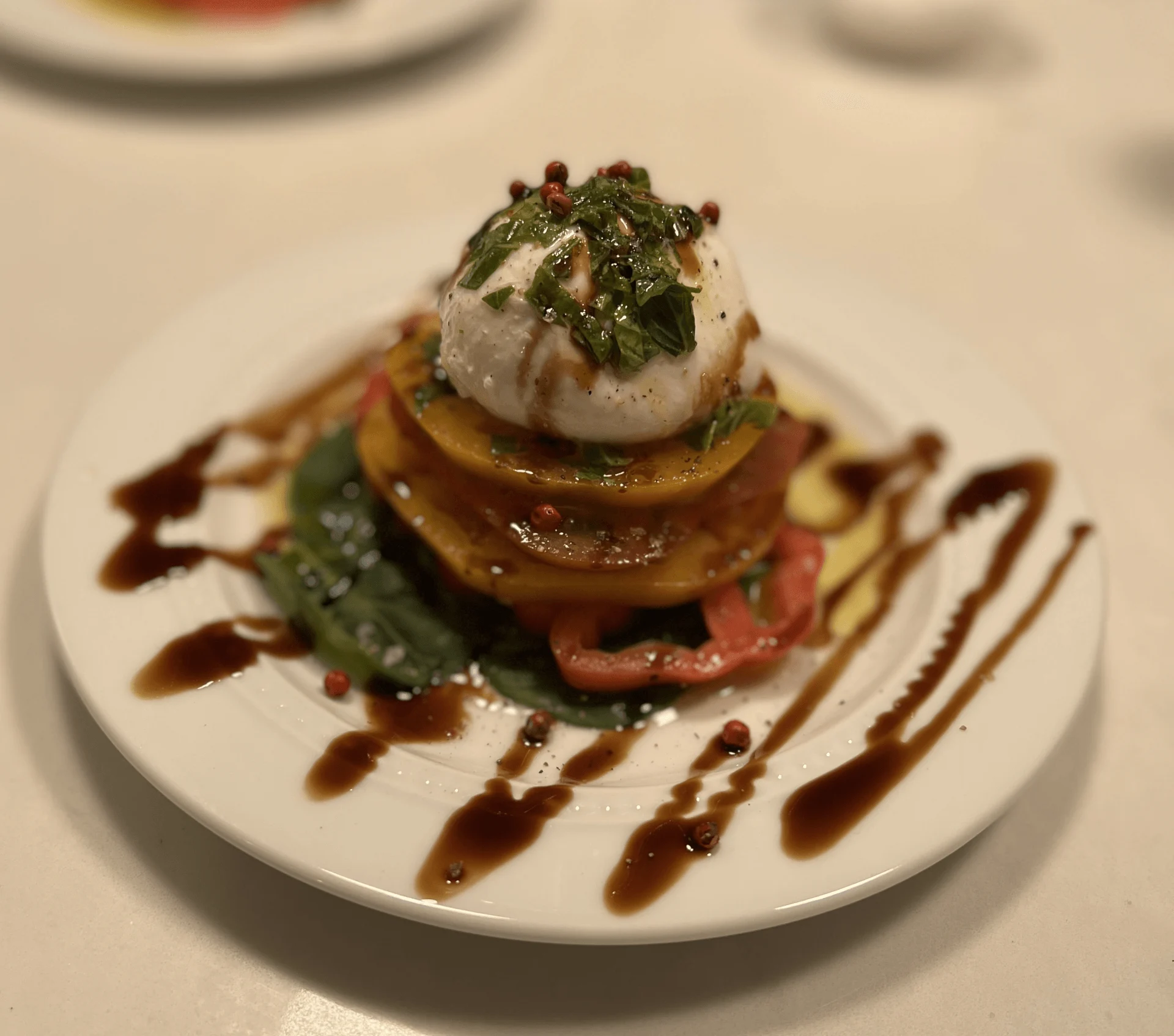 Burrata and layered heirloom tomatoes with herbs and balsamic drizzle.