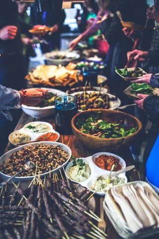 Guests share a casual buffet of salads and entrees at a long dining table.