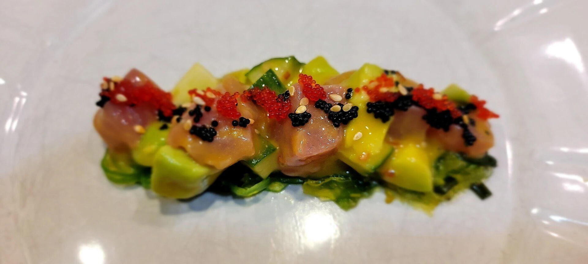 Bluefin toro with avocado, diced peppers, sesame seeds and greens.