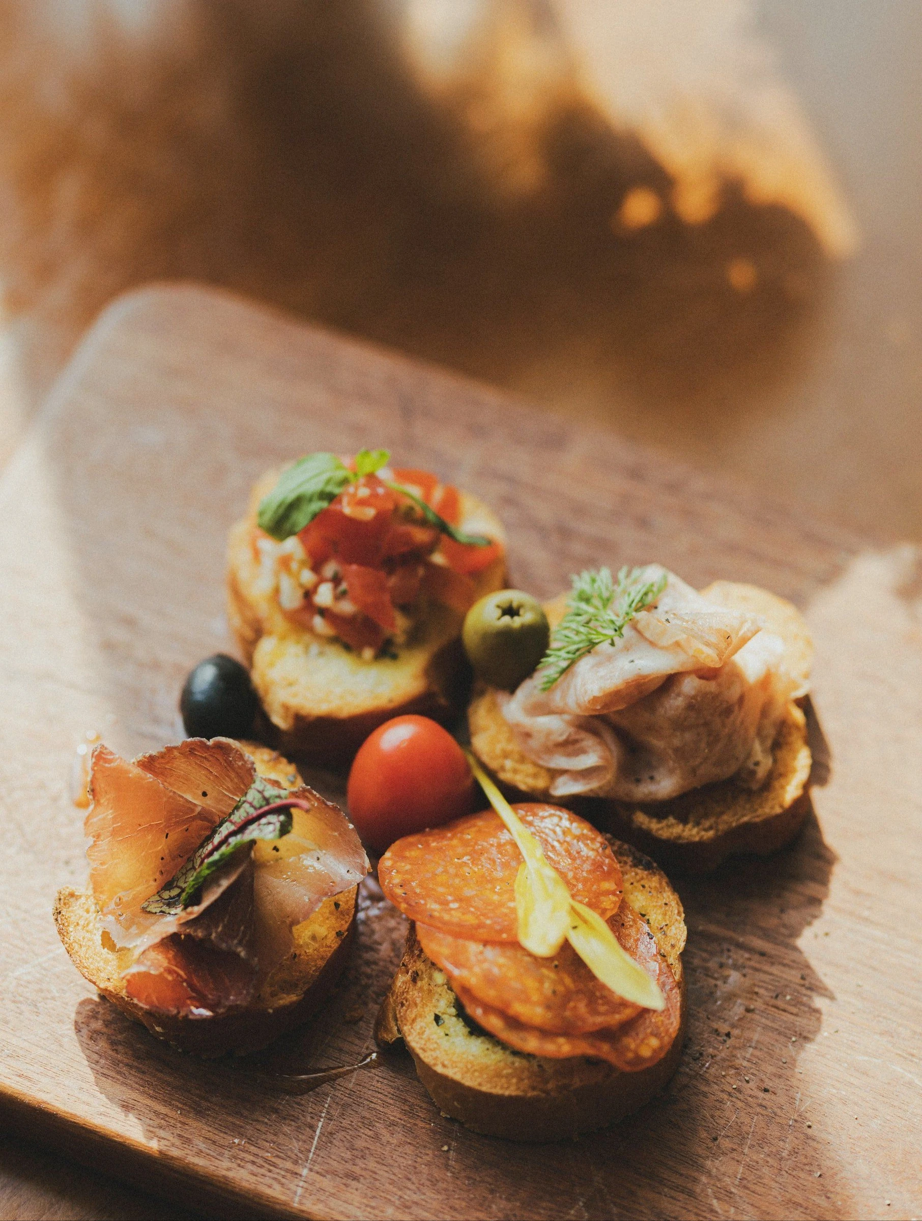 Small plated appetizers with colorful garnishes on a warm-toned table.